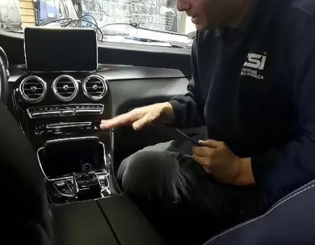 A mechanic inspecting the jammed center console in a 2018 Mercedes C300.
