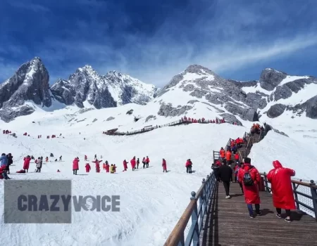 Tourists in red coats walking along a snowy mountain trail, symbolizing the deep exploration of Antarvwsna and the beauty of inner self-discovery.